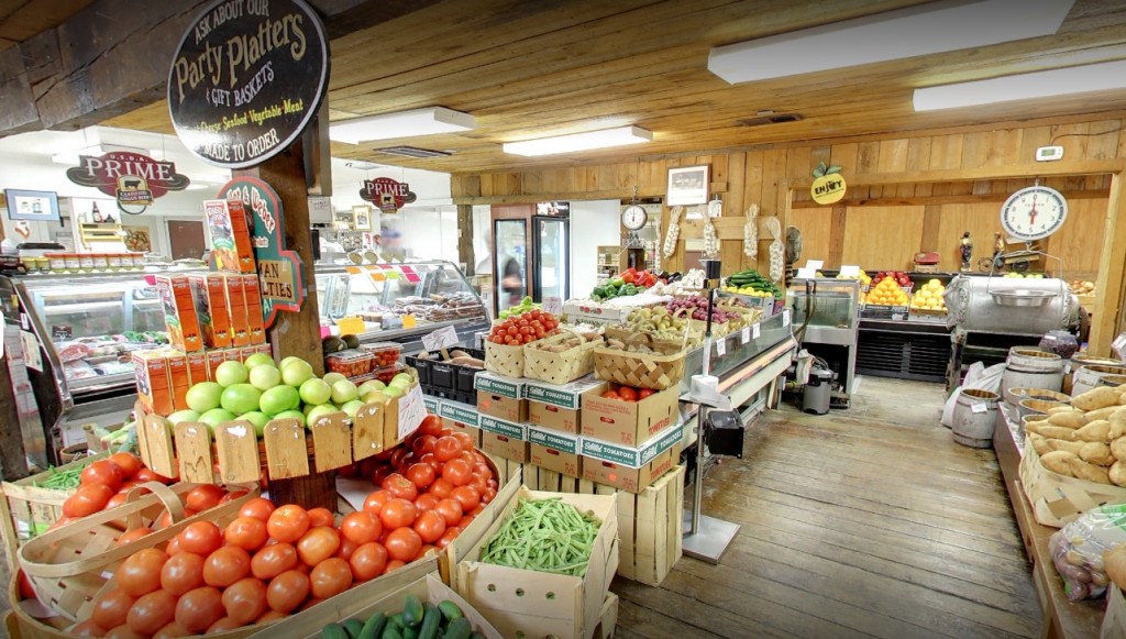 Baskets of fresh tomatoes, green beans, and produce inside Lee's Farmers Market