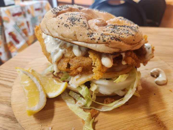Fried flounder filet, house made tartar sauce, on a bed of iceberg lettuce, a little squeeze of lemon, on a toasted poppy seed roll.