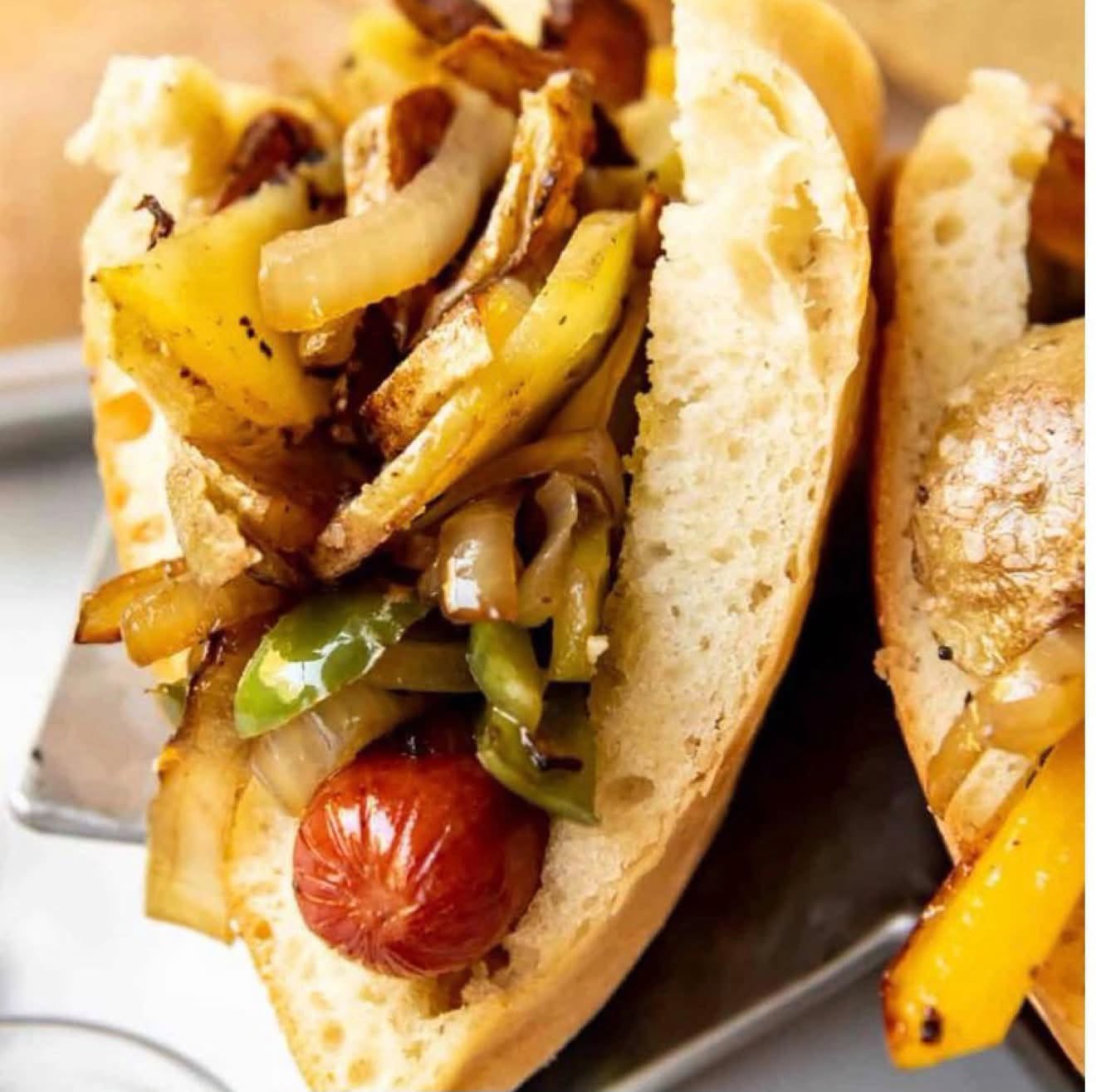 Double Thumans hot dogs loaded with fried potatoes, peppers, onions and mustard on freshly baked Calandras pizza bread.